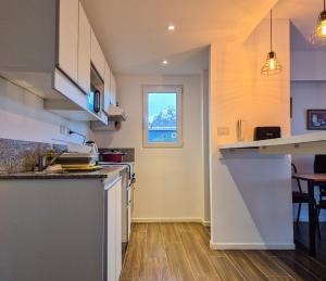 cocina con encimera y ventana en Bahia Mágica - 1 dormitorio, en Ushuaia 13 fotos más