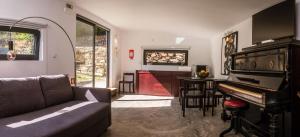 ein Wohnzimmer mit einer Couch und einem Klavier in der Unterkunft BABhouse Villa Jardim das Oliveiras in Nagoselo do Douro