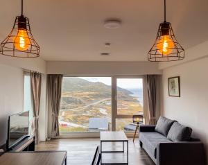 Una sala de estar con un sofá y una ventana grande. en Bahia Mágica - 1 dormitorio, en Ushuaia
