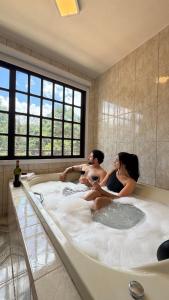 a group of people sitting in a bath tub at Chalés Leopoldo em Monte Verde in Monte Verde