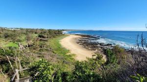 a sandy beach with the ocean in the background at the beach hive in Diamond Beach