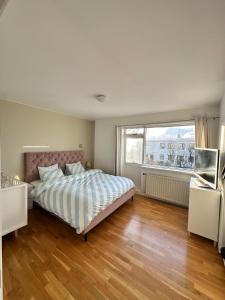 Un dormitorio con una cama y una ventana grande. en Family house near airport, en Keflavík