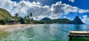 a view of a beach with mountains in the background at Jardin Damon in Soufrière