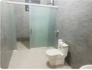 a bathroom with a toilet and a glass shower at Brand new house in Kigali