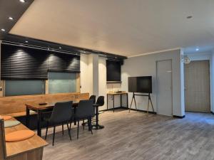 a room with a table and chairs and a television at Paju Sabai Pension in Paju