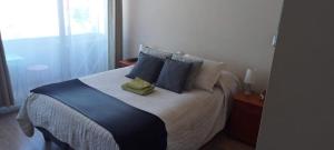 a bedroom with a large bed with blue pillows at depto nuevo temuco in Temuco