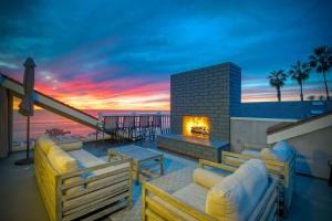 a patio with couches and a fireplace with a sunset at 3636 Carlsbad Blvd - Upper in Carlsbad