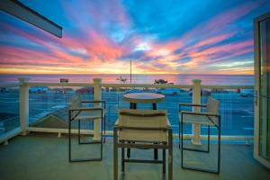 a balcony with a table and chairs and a sunset at 3636 Carlsbad Blvd - Upper in Carlsbad