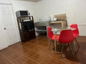 a dining room with a table and red chairs at Perezoso View Apartment in Guápiles