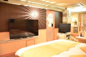 a bedroom with a large flat screen tv on a wall at Hotel Coco de Sole & Coco de Mono(Love Hotel) in Oita