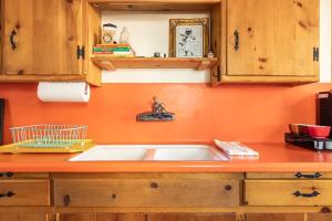 a kitchen with a sink and an orange wall at Chair 9 Chalet in Big Bear Lake +44 photos