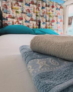 a bed with blue pillows and a blanket on it at Campervan Dory in Lisbon +7 photos