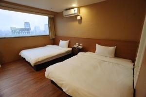 a hotel room with two beds and a window at Banciaoking Hotel in Taipei