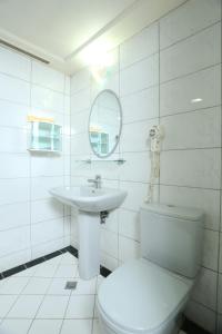 Banciaoking Hotel في تايبيه: حمام ابيض مع مرحاض ومغسلة