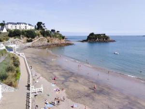 un gruppo di persone su una spiaggia vicino all'oceano di Stone House by Les Godelins Beach a Gicquel Altre 7 foto