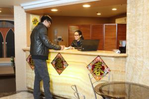 a man and a woman standing at a counter at Banciaoking Hotel in Taipei