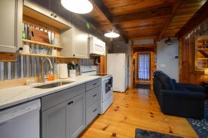 a kitchen with white cabinets and a blue couch at Whispering Winds in Rogers