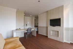a living room with a couch and a television on a wall at Flat moderno Hotel Mercure Líder in Brasilia