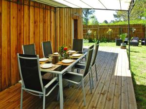 eine Holzterrasse mit einem Tisch und Stühlen in der Unterkunft holiday home, Le Porge in Le Porge