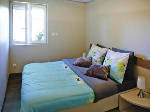 Schlafzimmer mit einem Bett mit blauer Bettwäsche und Kissen in der Unterkunft holiday home, Le Porge in Le Porge