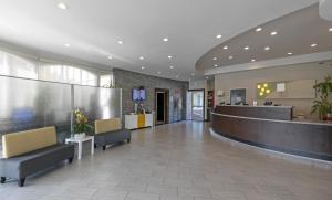 a lobby of a hospital with chairs and a counter at Pacific Stay Hotel in West Covina +15 photos