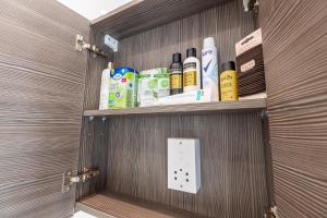 a cabinet with a bunch of products on it at The Kensington Residence - Central London Base in London +20 photos