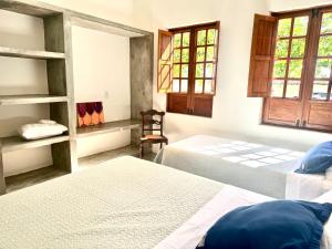 a bedroom with two beds and a chair in it at Casa Amor With Sea View in Goiana