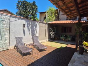 two chairs sitting on a wooden deck at CASA ALECRIM PISCINA PRIVATIVA COM Dec MOVEL Ideal Crianças in Niterói