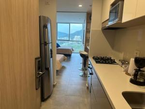 a kitchen with a stainless steel refrigerator and a room at Rodadero sur, 12th floor diagonal view to the cute sea in Gaira