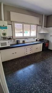 サンタ・ロサ・デ・カラムチタにあるLa casa de Renaのキッチン(白いキャビネット、青いカウンタートップ付)