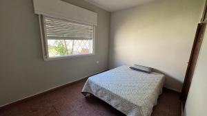 サンタ・ロサ・デ・カラムチタにあるLa casa de Renaのベッドと窓のある小さな寝室
