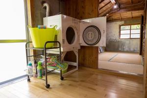 une pièce avec une machine à laver dans une maison dans l'établissement 猫宿 Muribushi-inn, à Motobu