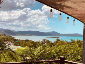 a view of the ocean from a house with lights at The Nest! in Cannonvale