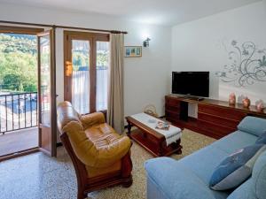 a living room with a couch and a tv at Belvilla by OYO Apartamento â€œLa Cabanaâ€ in Bohí