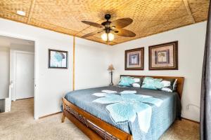 a bedroom with a bed with a ceiling fan at Charming 2 Bedroom Condo, Walk to Historic Kailua Village Hotspots with King Bed, AC in Kailua-Kona +14 photos