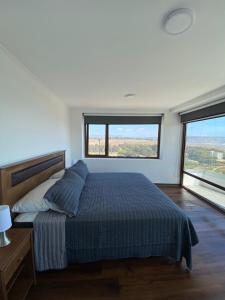 a bedroom with a bed and two large windows at Pingel Home Vista Mar in Valparaíso