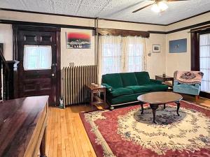 ein Wohnzimmer mit einer grünen Couch und einem Tisch in der Unterkunft Kurtz Cottage - Y856 in York + 29 Fotos