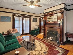 ein Wohnzimmer mit einer grünen Couch und einem Kamin in der Unterkunft Kurtz Cottage - Y856 in York