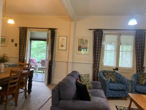 a living room with a couch and a table at Capers Cottage and Barn Accommodation in Wollombi