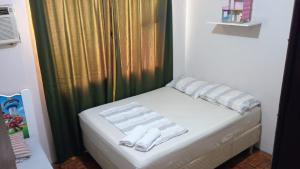 a small bed in a room with a green curtain at Morada do Altíssimo I in Uruguaiana