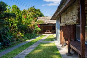 - un jardin avec un banc à côté d'une maison dans l'établissement 猫宿 Muribushi-inn, à Motobu