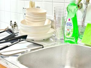 a pile of dishes sitting on a kitchen sink at Shinjuku Waseda home4 in Tokyo