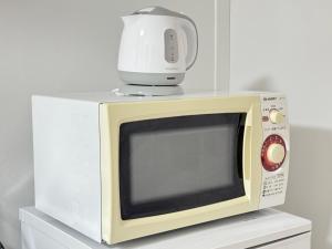 a white microwave with a food processor on top of it at Shinjuku Waseda home4 in Tokyo
