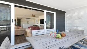 a dining room table with a bowl of fruit on it at Coastal Palm House By Wine Coast Holiday Rentals in Aldinga Beach