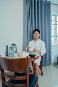 a woman sitting at a table in a room at White Corner Hotel in Phnom Penh