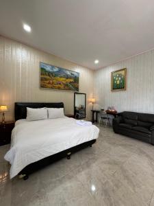a bedroom with a large bed and a couch at Villa Robert in Pineleng