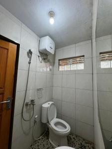 a bathroom with a toilet and a shower stall at Villa Robert in Pineleng +24 photos