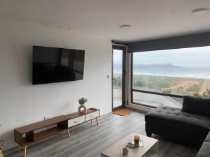 a living room with a couch and a large window at Pingel Home Vista Mar in Valparaíso