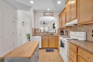 a kitchen with white appliances and wooden cabinets at Cozy 2B Townhouse - King Bed in Concord