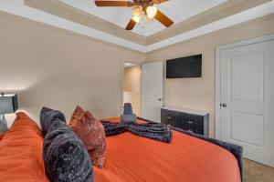 a bedroom with an orange bed and a ceiling fan at Cozy 2B Townhouse - King Bed in Concord +10 photos